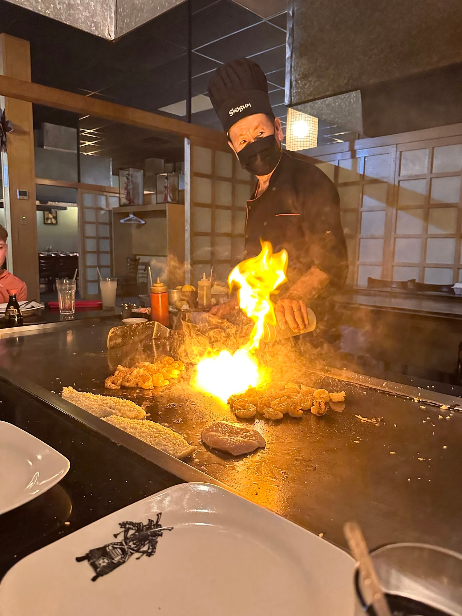 Chef preparing Japanese teppanyaki at a Shogun-style grill
